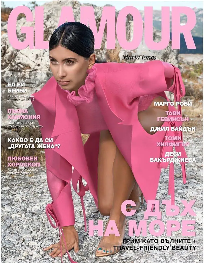 Обложка Glamour: модель в ярко-розовом образе на каменистом берегу